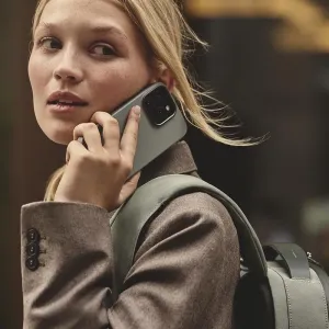 Mujjo-Lederhülle für iPhone 16 Pro Max in einer Alltagsaufnahme, ans Ohr gehalten, mit sichtbarer Aussparung für die Rückkamera