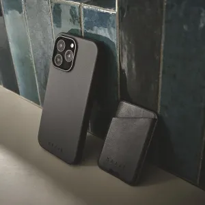 Deux coques en cuir Mujjo pour iPhone 16 Pro Max noires, avec une découpe surélevée pour l’appareil photo et un logo en relief.