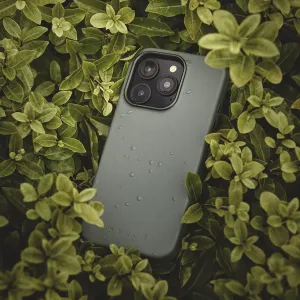Mujjo-Lederhülle für das iPhone 16 Pro Max in Rauchgrün mit erhabenem Kameraausschnitt, abgebildet zwischen grünen Blättern.