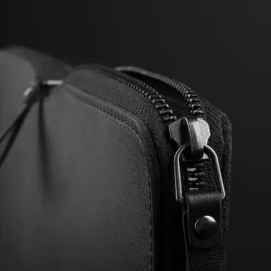 Housse folio Mujjo pour ordinateur portable noire, avec extérieur texturé, finitions en cuir et poignée de transport