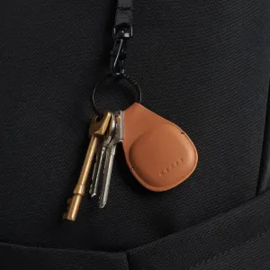 Porte-clés AirTag Mujjo en cuir fauve avec anneau en métal noir et clés attachées sur une lanière noire texturée