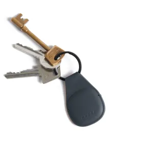 Mujjo Leder-AirTag-Schlüsselanhänger aus dunklem Leder mit schwarzem Ring und befestigten Schlüsseln auf weißem Hintergrund