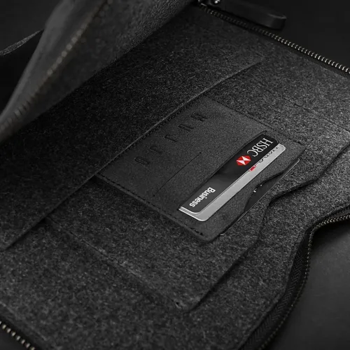 Mujjo folio futrālis 13 collu MacBook Pro atvērts ar redzamu tumšu rāvējslēdzēju, iekšpusi ar filca oderējumu, kabatām un slotu kartēm.