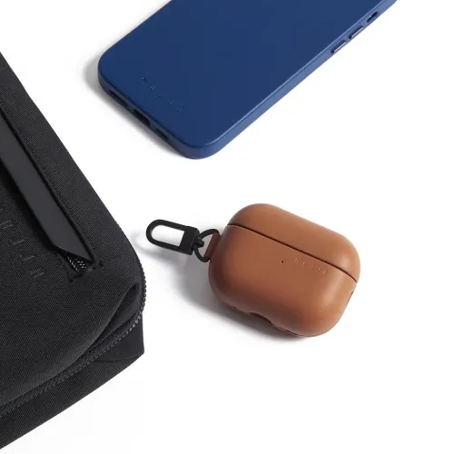 Mujjo AirPods Pro case in blue and tan with clip, shown beside a matching black zip pouch on white background