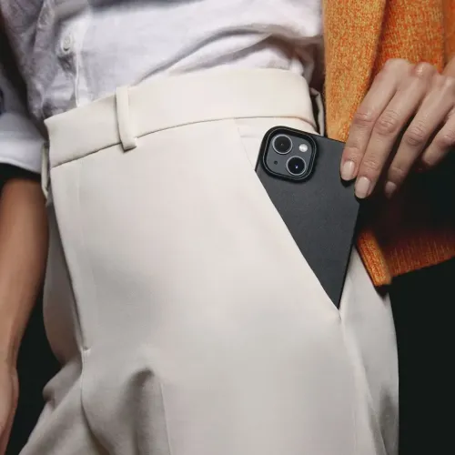 Étui en cuir Mujjo pour iPhone 14 Pro Max glissé dans la ceinture, montrant la découpe pour l’appareil photo et la fine finition noire