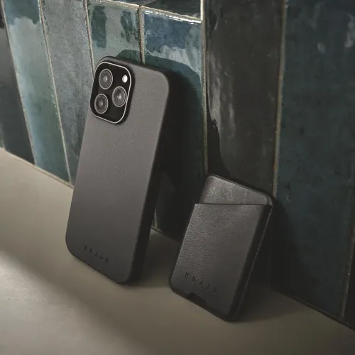 Deux coques en cuir Mujjo pour iPhone 16 Pro Max noires, avec une découpe surélevée pour l’appareil photo et un logo en relief.