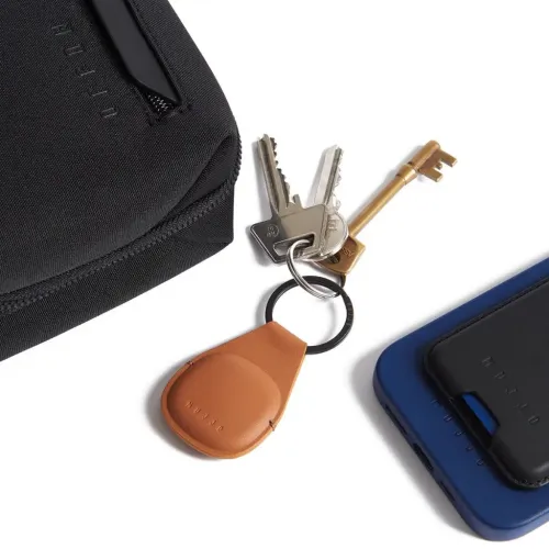 Mujjo Canopy Keychain tan leather AirTag holder with black key ring and attached keys on white background