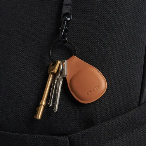 Porte-clés AirTag Mujjo en cuir fauve avec anneau en métal noir et clés attachées sur une lanière noire texturée
