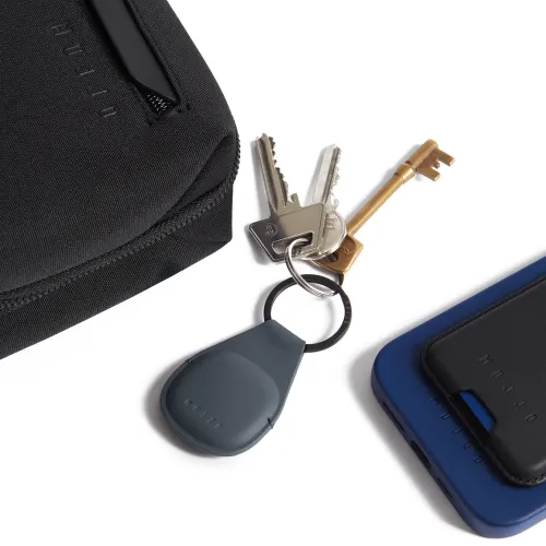 Mujjo Leather AirTag Keychain i grått läder, fäst vid nycklar med präglad Mujjo-logotyp