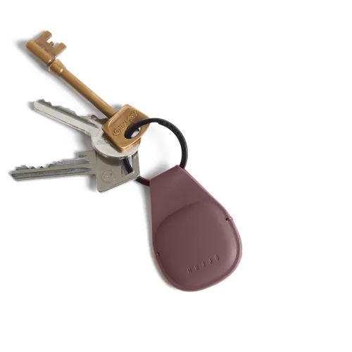 Mujjo AirTag keychain in bronze-red leather with black ring and 3D-shaped pocket, attached to a keychain on a white background.